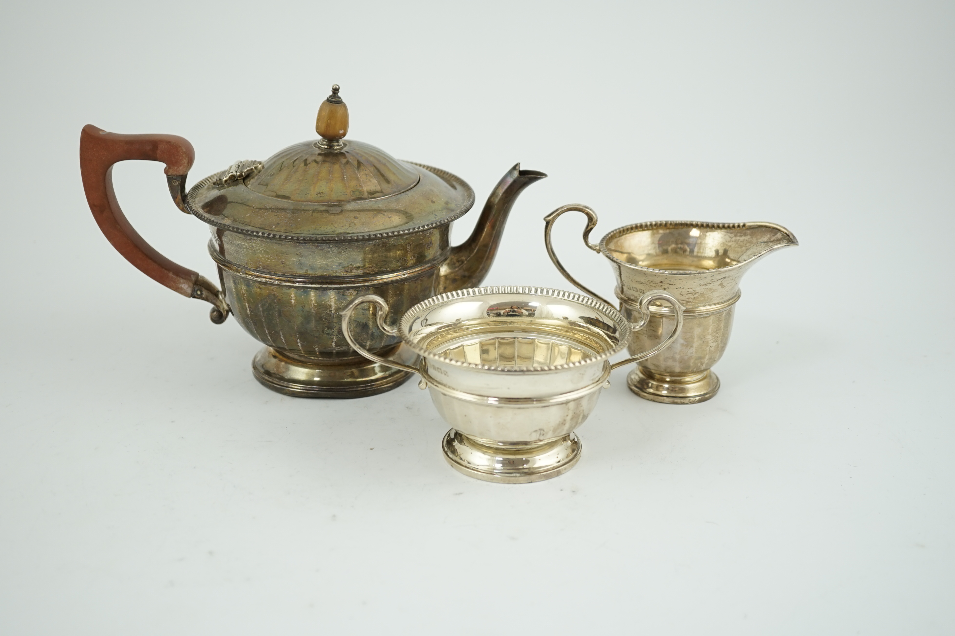 A George V panelled silver three piece tea set, by Adie Brothers